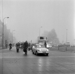 125613 Afbeelding van het verkeer op de rotonde op het Leidseveer te Utrecht, tijdens mist.